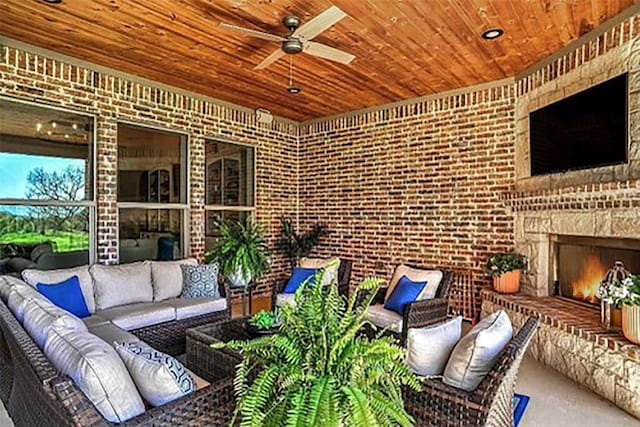 view of patio with an outdoor living space with a fireplace and a ceiling fan