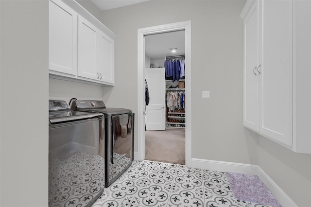 laundry area featuring washer and dryer, baseboards, cabinet space, and light tile patterned floors