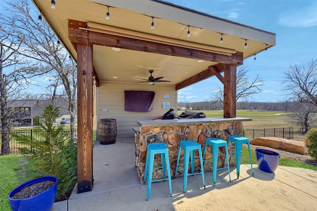 view of patio / terrace featuring ceiling fan, outdoor dry bar, and fence