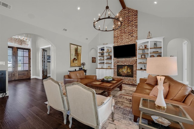 living room with visible vents, arched walkways, high vaulted ceiling, and wood finished floors