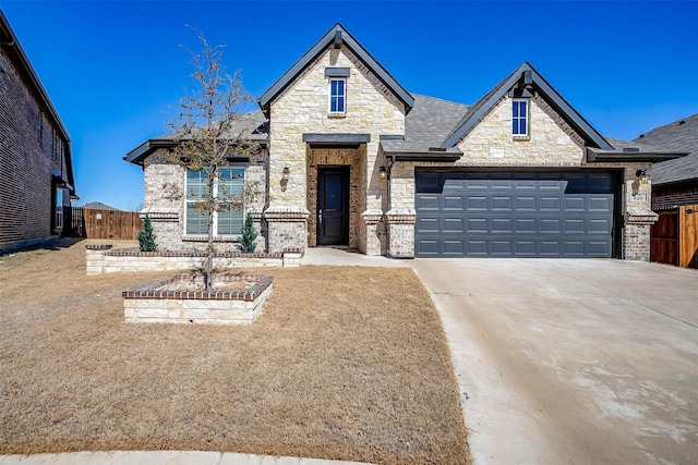 french country home with a garage, fence, and concrete driveway