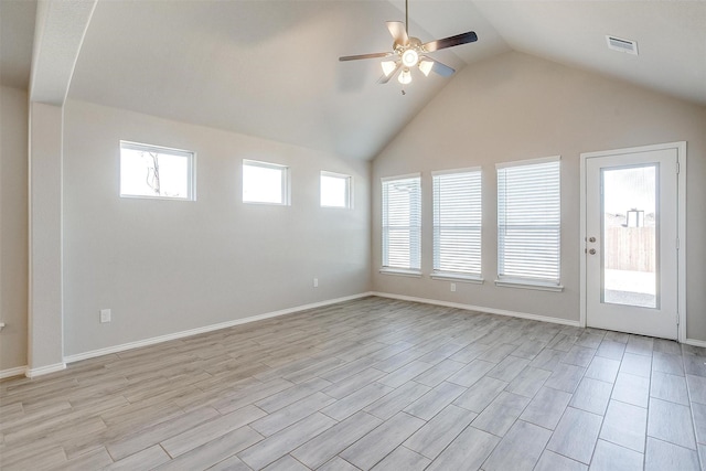 spare room featuring ceiling fan, lofted ceiling, light wood-style flooring, visible vents, and baseboards