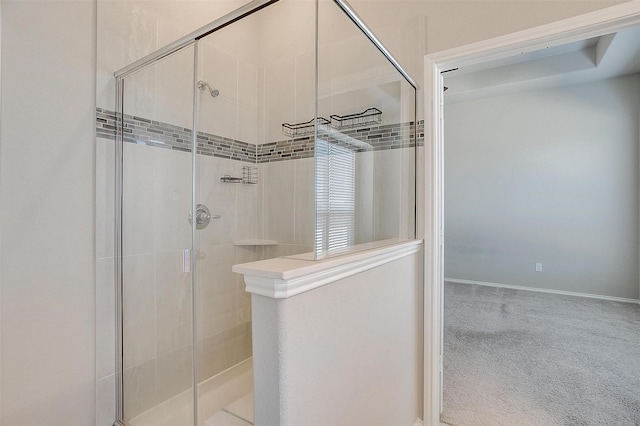 bathroom featuring a stall shower and baseboards