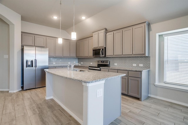 kitchen featuring stainless steel appliances, a sink, gray cabinetry, and tasteful backsplash
