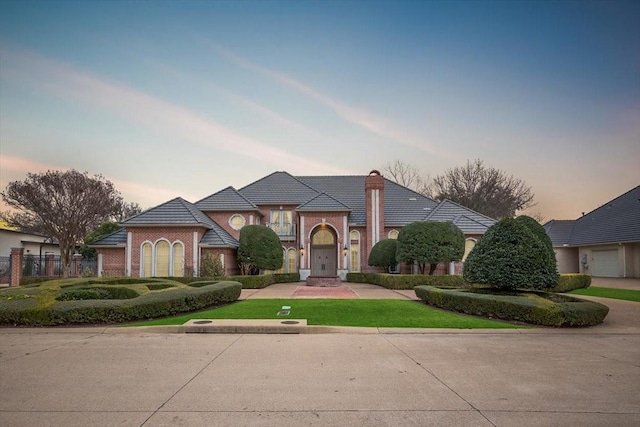 view of front of home featuring brick siding and fence