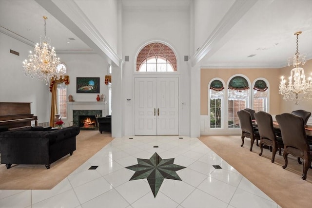 foyer entrance featuring a chandelier, carpet flooring, ornamental molding, and tile patterned floors