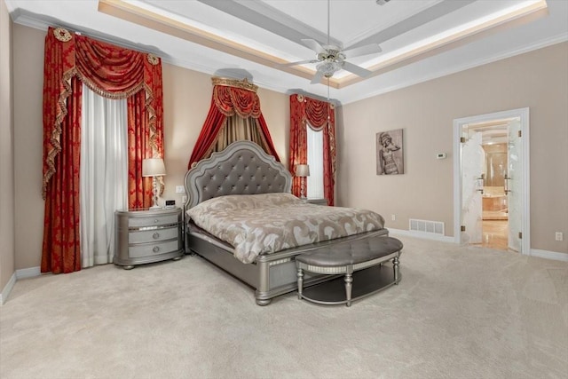 bedroom featuring carpet flooring, visible vents, baseboards, a raised ceiling, and crown molding