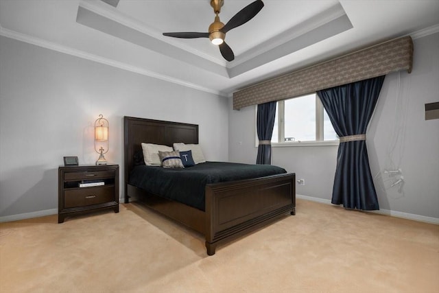 bedroom with ceiling fan, light colored carpet, baseboards, ornamental molding, and a tray ceiling