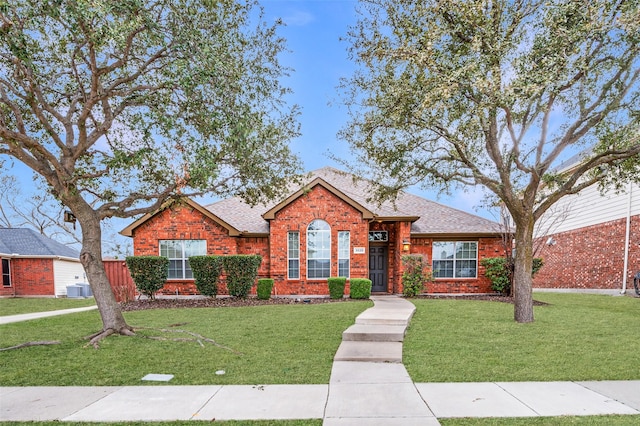 single story home with brick siding, a shingled roof, and central AC unit