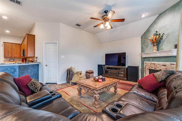 living room with lofted ceiling, ceiling fan, a fireplace, and visible vents