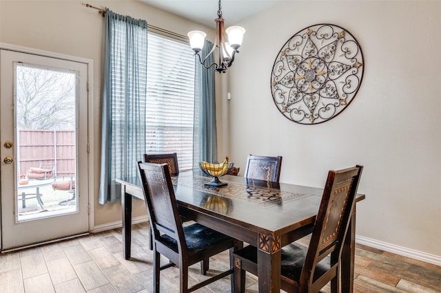 dining space with a chandelier, light wood-type flooring, and baseboards