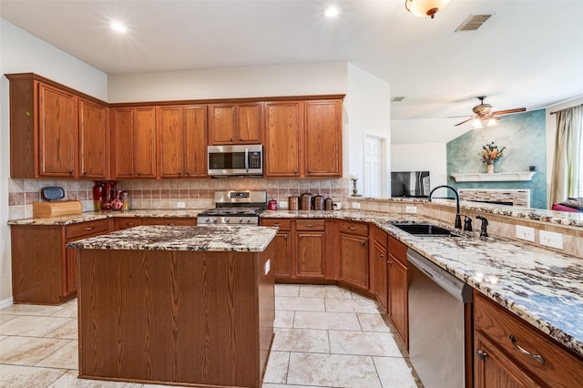 kitchen with tasteful backsplash, visible vents, brown cabinetry, stainless steel appliances, and a sink