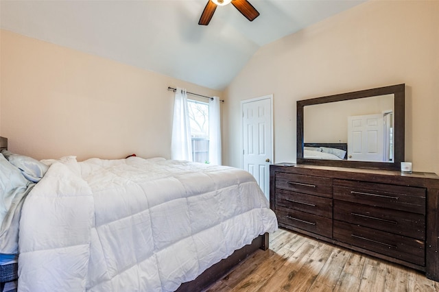 bedroom with vaulted ceiling, ceiling fan, and light wood-style floors