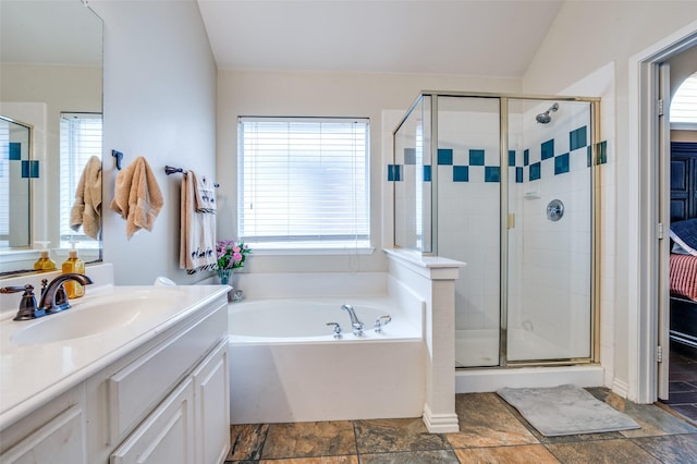 full bath with a shower stall, a bath, vanity, and stone tile flooring