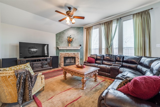 living area featuring vaulted ceiling, a fireplace with raised hearth, and ceiling fan