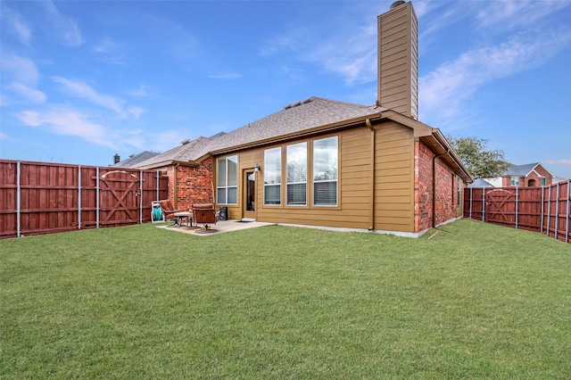 rear view of house featuring a fenced backyard, brick siding, a lawn, a chimney, and a patio area