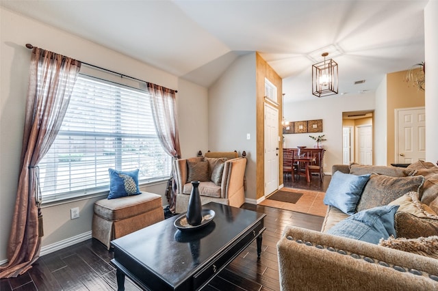 living room featuring a chandelier, vaulted ceiling, baseboards, and wood finished floors