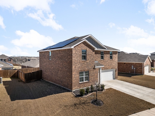 view of front of home featuring solar panels, board and batten siding, fence, a garage, and driveway