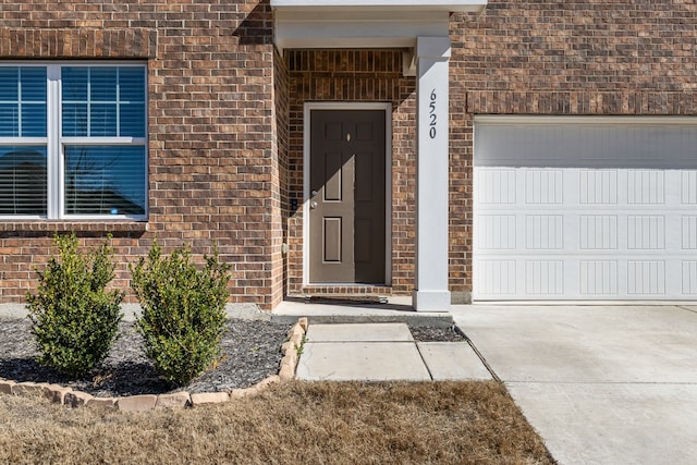 entrance to property featuring brick siding and an attached garage