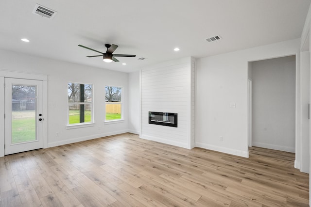 unfurnished living room with light wood-type flooring, a large fireplace, visible vents, and recessed lighting