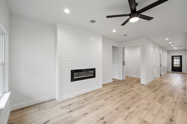 unfurnished living room featuring recessed lighting, visible vents, light wood-style floors, a large fireplace, and baseboards