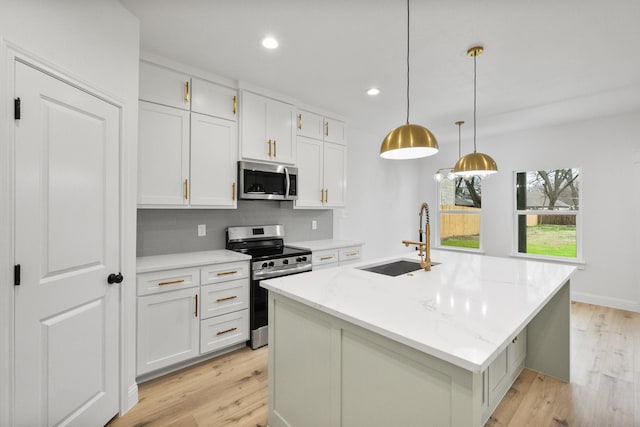 kitchen featuring white cabinets, stainless steel appliances, light wood-type flooring, a sink, and recessed lighting