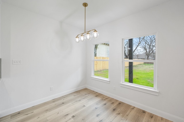 unfurnished dining area featuring baseboards and wood finished floors