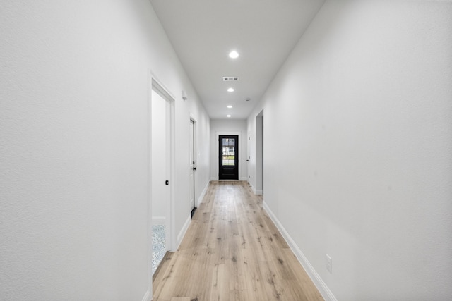 hallway with light wood-type flooring, visible vents, baseboards, and recessed lighting