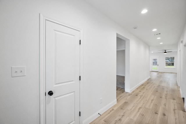 hallway with baseboards, light wood finished floors, visible vents, and recessed lighting