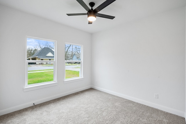 unfurnished room featuring carpet floors, baseboards, and a ceiling fan