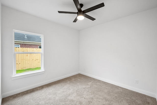 carpeted empty room featuring ceiling fan and baseboards