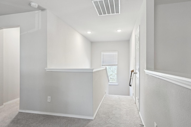 corridor featuring an upstairs landing, carpet flooring, visible vents, and baseboards