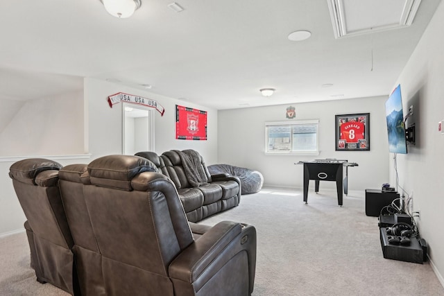 carpeted living area with attic access and baseboards