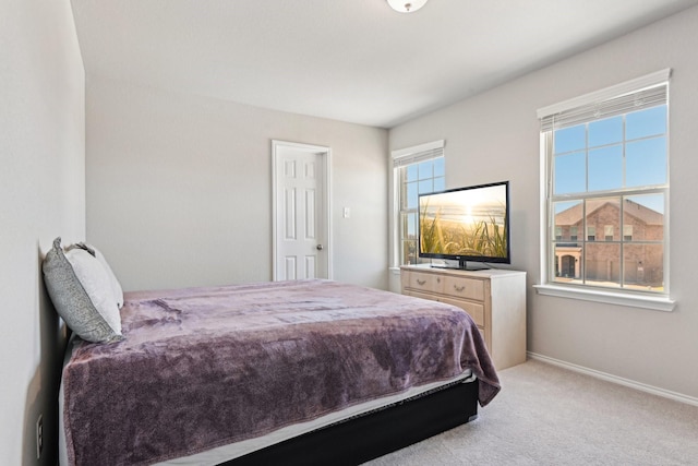 bedroom with light carpet and baseboards