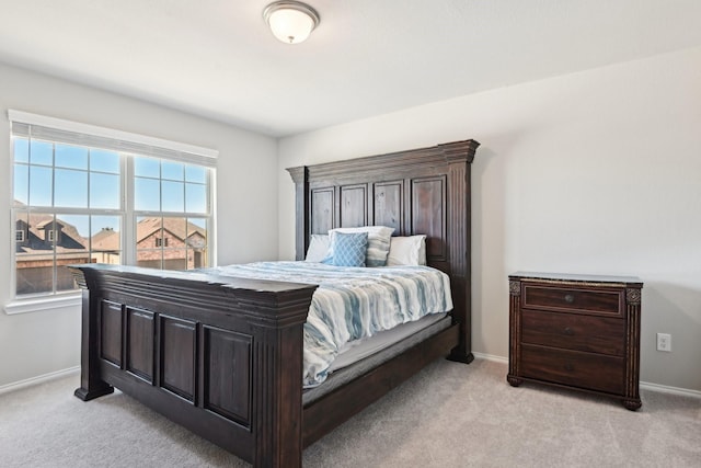 bedroom with light carpet and baseboards