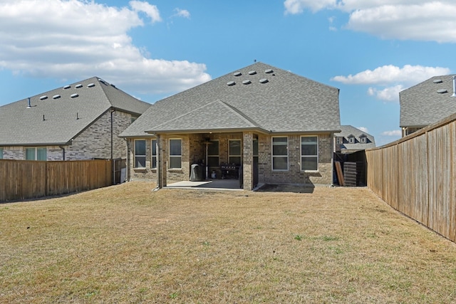 back of house with ceiling fan, a patio, a fenced backyard, brick siding, and a lawn