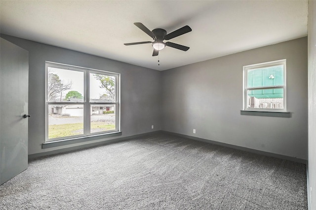 carpeted empty room featuring ceiling fan and baseboards