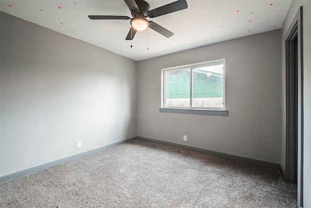 empty room featuring carpet flooring, a ceiling fan, and baseboards