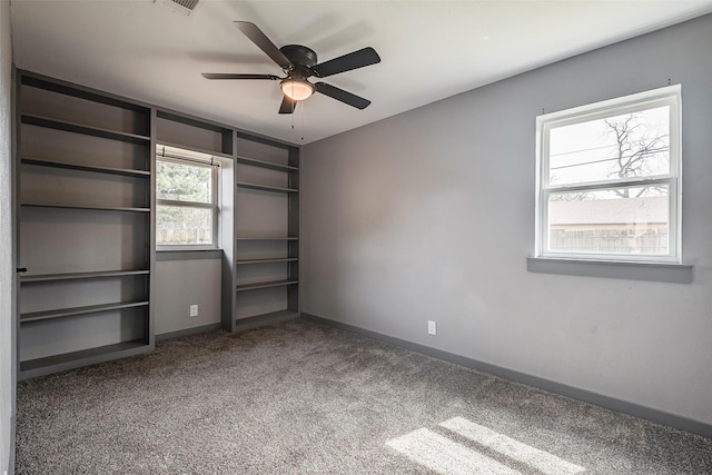 unfurnished bedroom with carpet floors, a ceiling fan, visible vents, and baseboards