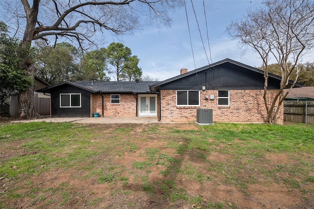 rear view of house with a patio, a chimney, fence, cooling unit, and brick siding