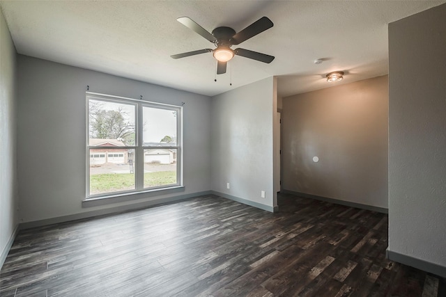 empty room featuring dark wood-style floors, ceiling fan, a textured ceiling, and baseboards