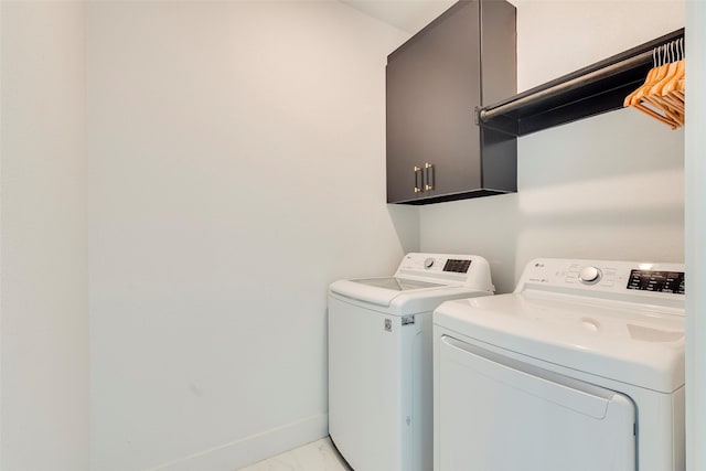 clothes washing area featuring marble finish floor, cabinet space, baseboards, and separate washer and dryer