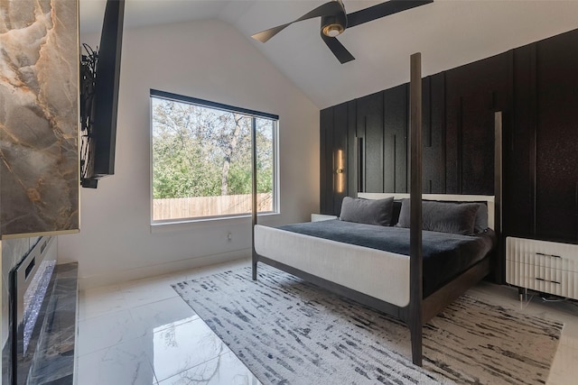 bedroom featuring a ceiling fan, marble finish floor, vaulted ceiling, and baseboards