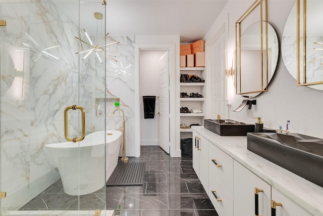 bathroom with a marble finish shower, a soaking tub, marble finish floor, vanity, and stone wall