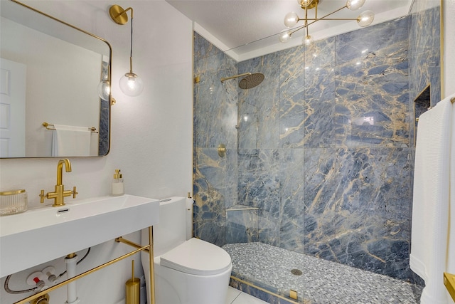 bathroom featuring a marble finish shower, vanity, toilet, and a textured ceiling