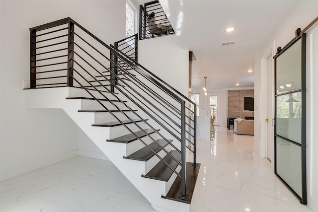 staircase with marble finish floor, recessed lighting, visible vents, a barn door, and baseboards