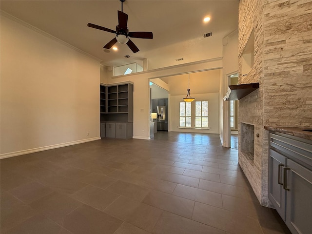 unfurnished living room featuring a fireplace, visible vents, baseboards, a ceiling fan, and crown molding