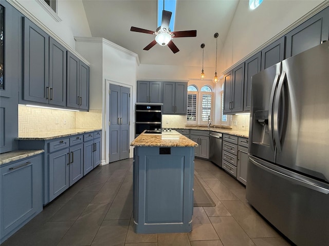 kitchen with light stone counters, stainless steel appliances, tasteful backsplash, a kitchen island, and high vaulted ceiling