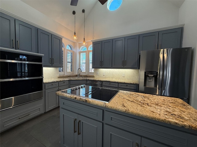 kitchen featuring decorative backsplash, light stone counters, hanging light fixtures, gray cabinetry, and black appliances