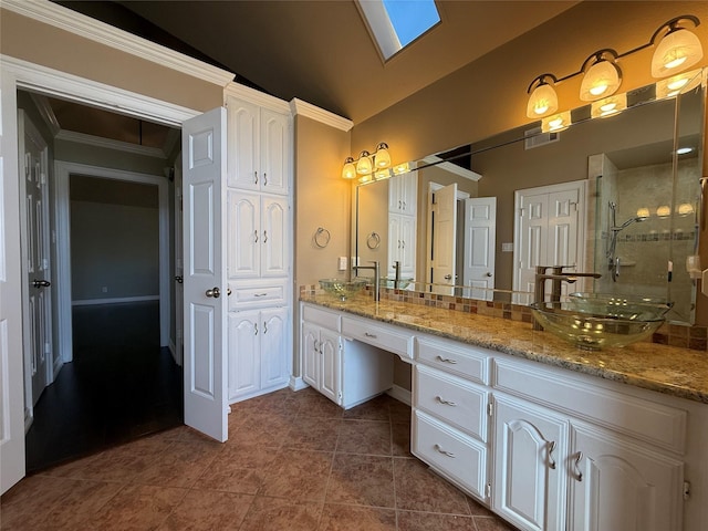 bathroom featuring double vanity, a shower stall, vaulted ceiling, and a sink